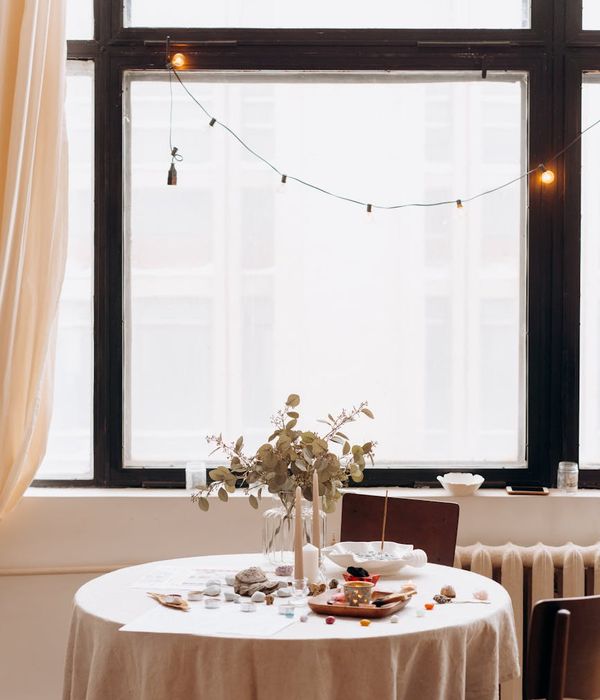Woman in a calm yoga pose in a bright, minimalist room.